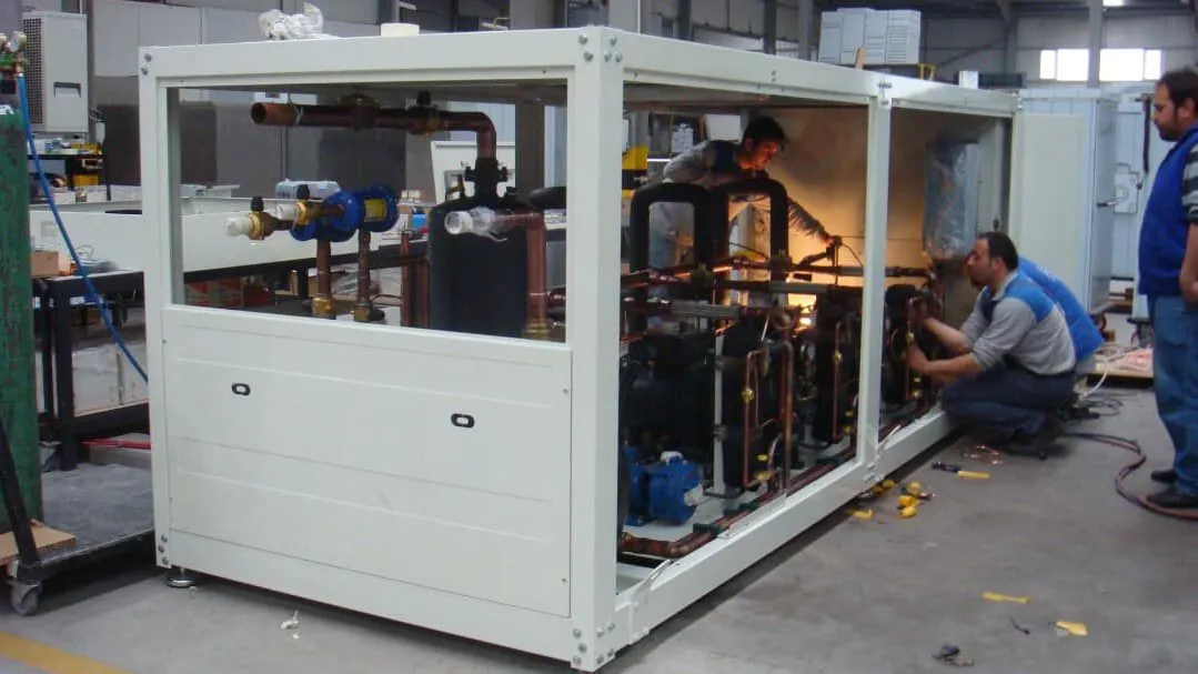 Teknisyenler atölyede bir chiller grubunun soğutma devresi üzerinde çalışırken